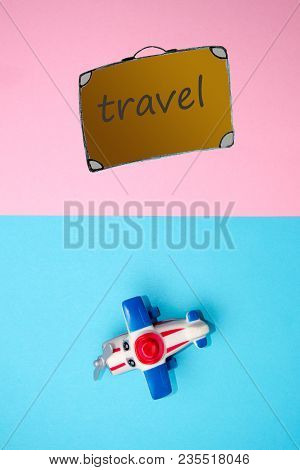 Flat Lay Design Of Travel Concept With Plane And Travel Bag On Blue And Pink