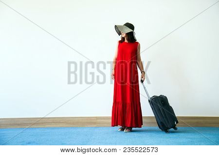 Women In Red Dress And Hatt With Suitcase And White Wall Background