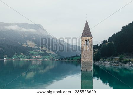Beautiful view of the lake Resia. Famous tower in the water. Alps, Italy, Europe. Landscape photography