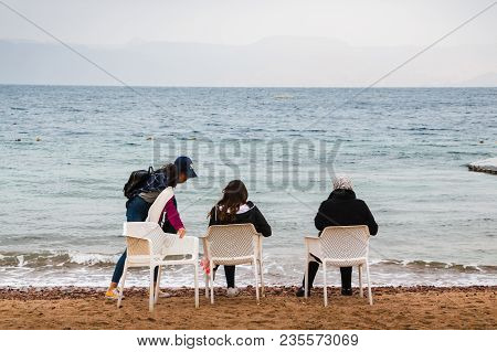 Jordan, Akaba - December 24, 2017: Three Girl On The Beach Near Sea In An Cold Day