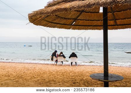 Jordan, Akaba - December 24, 2017: Three Girl On The Beach Near Sea In An Cold Day