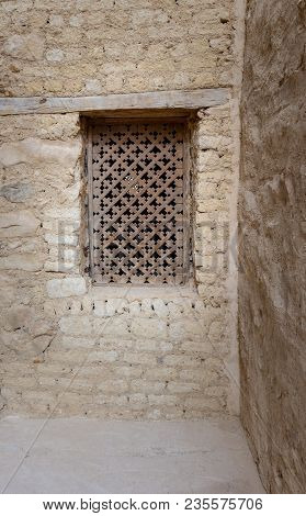 Ancient Wooden Window With Geometrical Pattern Based On The Christian Cross On External Brick Stone 