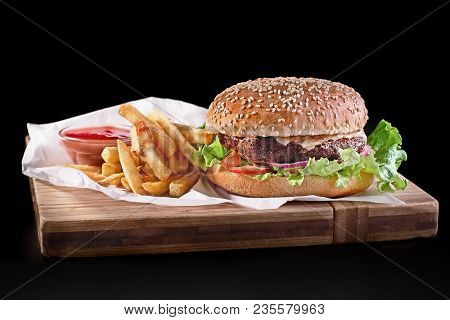 Burger With French Fries On Wooden Cutting Board Isolated On Black Background, Close-up Shot, Select