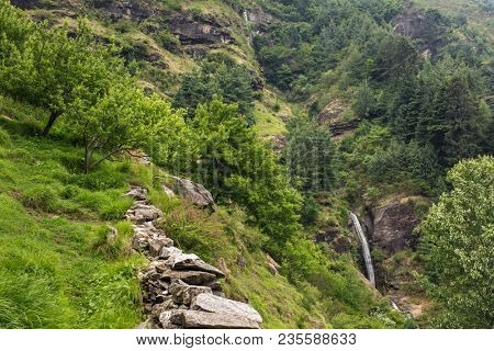Summer mountain landscape with small waterfall and apple garden in Vashisht village Himachal Pradesh, India.