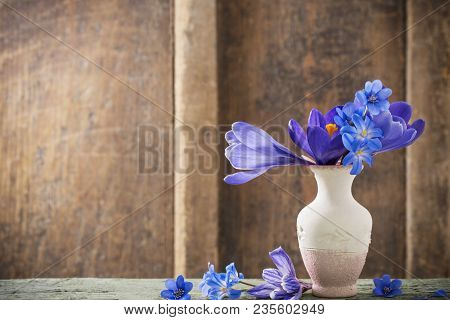 Spring Flowers In Vase On Wooden Background