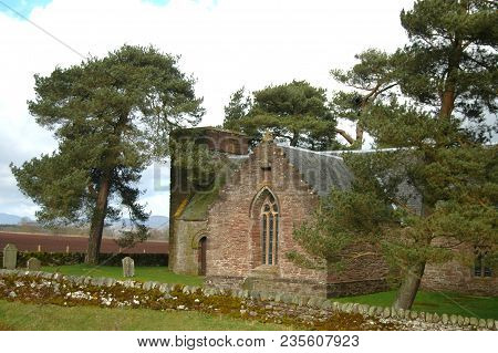 Perth, Scotland - April 7th 2017: Tulliburdine Chapel In Perthshire, With Pine Trees And Gravestone 