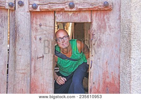 A Tourist Man Passes Through A Very Small And Low Door In The Temple Of Virupaksha, Hampi, India. A 