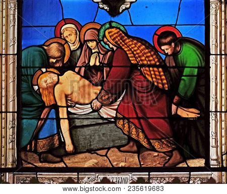 PARIS, FRANCE - JANUARY 10, 2018: 14th Stations of the Cross, Jesus is laid in the tomb and covered in incense, stained glass windows in the Saint Eugene - Saint Cecilia Church, Paris, France.