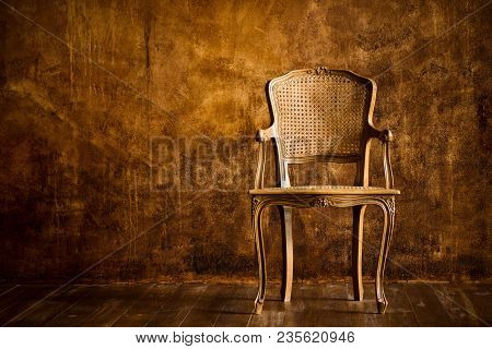 Old Chair On A Brown Wall Background