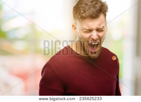 Handsome young man stressful, terrified in panic, shouting exasperated and frustrated. Unpleasant gesture. Annoying work drives me crazy