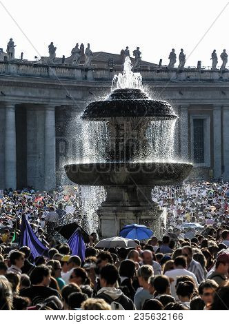 A Lot Of People Walking Around The Granite Fontaine Of St Peters Square In Vatican City. The Water F