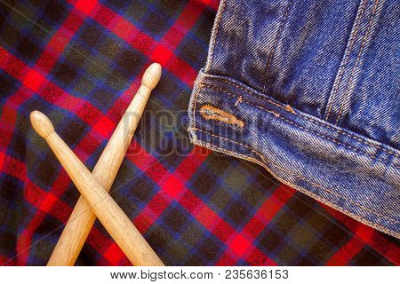 Drum Sticks Lie On A Scottish Cage And Jeans