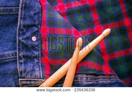 Drum Sticks Lie On A Scottish Cage And Jeans