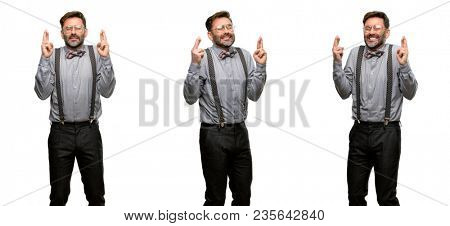 Middle age man, with beard and bow tie with crossed fingers asking for good luck