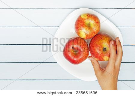 Apples On White Plate. Female Hand Grabing Apple. Copy Space. Top View.