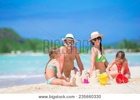 Family Making Sand Castle At Tropical Beach