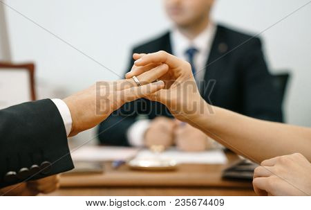 A Woman Puts A Wedding Ring In A Registry Office For A Man. Marriage And Hands Close-up Against The 