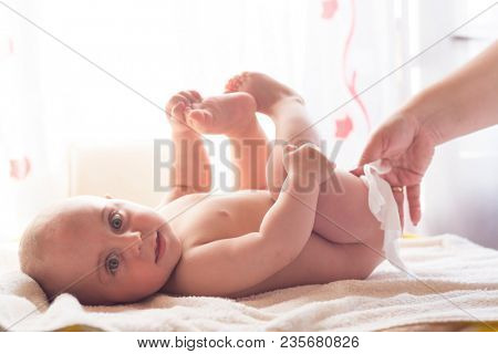 Hygiene - young momy wiping the baby skin with wet wipes. Cleaning wipe, pure, clean