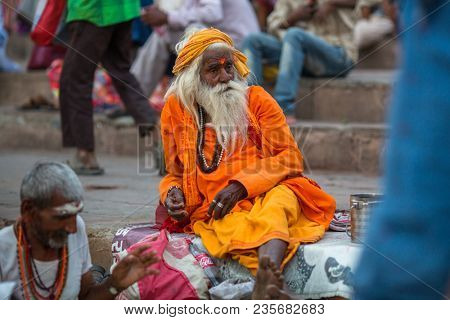VARANASI, INDIA - MAR 29, 2018: Sadhu or Baba (holy man) on the ghats of Ganges river. Normally a sadhu is a monk, renounced, renounced material enjoyment. In India from 4 to 5 million sadhu.