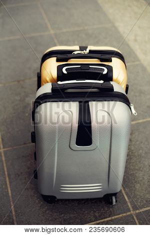 Two Suitcases On Grey Blurred Background. Summer Vacation And Travel Concept. Traveler Suitcase With