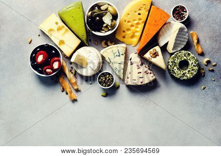 Assortment Of Hard, Semi-soft And Soft Cheeses With Olives, Grissini Bread Sticks, Capers, Grape, On