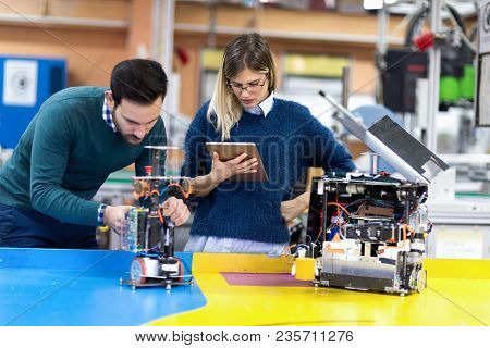 Young Attractive Students Of Mechatronics Working On Project Together