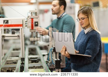 Young Attractive Students Of Mechatronics Working On Project Together