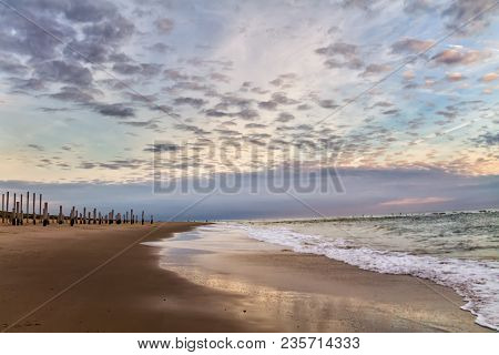 Beautiful Dramatic Cloudy Sky Over The Wooden Piles From The Beach, Petten, Holland, North Sea
