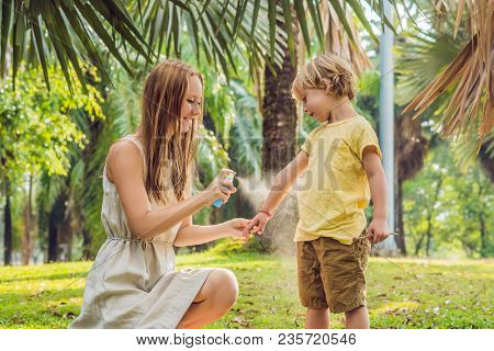 Mom And Son Use Mosquito Spray.spraying Insect Repellent On Skin Outdoor.