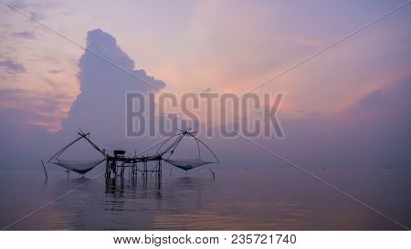 Sunrise At Pak Pra Lake,pattalung,thailand. Silhouette Of Traditional Fishing Method Using A Bamboo 