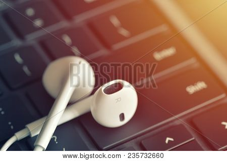 Headphones On The Keyboard. Online Straming Music Service Concept. Focus On Headphone