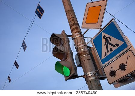 Chaos Traffic Signs And Traffic Light On A Pole Against A Blue Sky