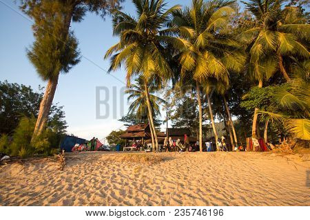 Lumut Perak, Malaysia - March 20, 2018: Family Traveler Sitting Under The Coconut Tree At The Beach.