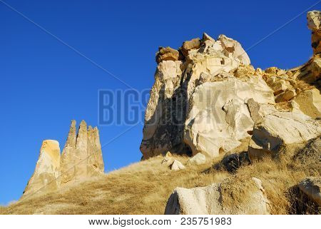Cappadocia Landscape. Fairy Chimneys And Caves In Cappadocia, Deep Blue Sky Over Fungous Forms Of Sa