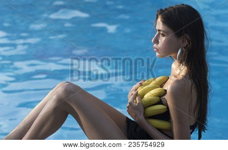 Woman Relax In Spa Pool. Woman With Tropical Fruit In Pool. Vitamin In Banana At Girl Sitting Near W