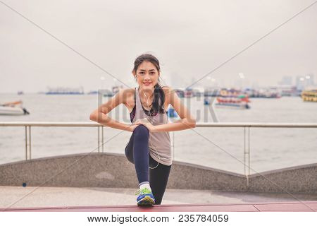 Sports Concept. Beautiful Girl Is Exercising On The Beach With Warm Up. Beautiful Girl Is Happy To E
