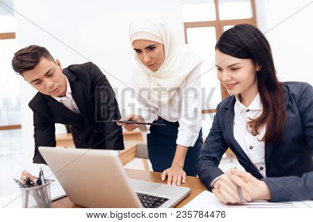 The Arab Woman In Hijab Works In The Office Together With Her Colleagues. They Are Engaged In Busine