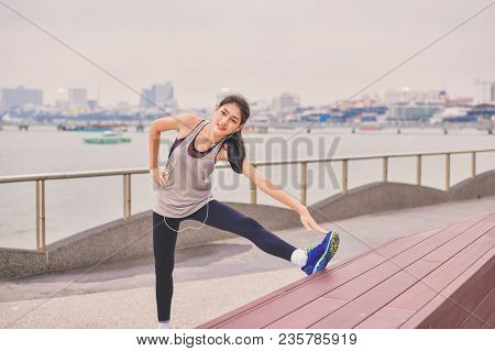 Sports Concept. Beautiful Girl Is Exercising On The Beach With Warm Up. Beautiful Girl Is Happy To E