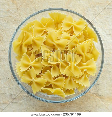 Farfalle Raw Farfallini Pasta In A Glass Bowl On A Wooden Table Texture Background, In The Center Cl