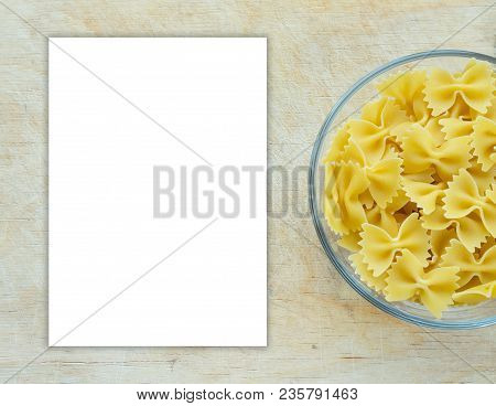 Farfalle Raw Farfallini Pasta In A Glass Cup On A Wooden Table Textured Background With A Side. Clos