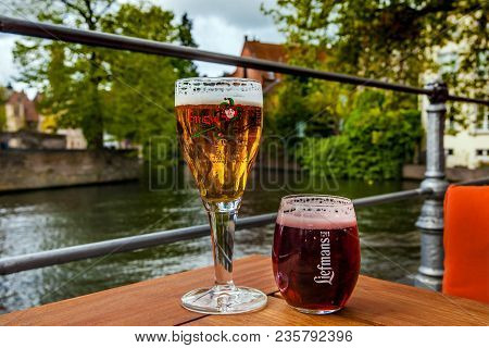 Bruges, Belgium - April, 2017: Two Glasses Of Belgian Beer Standing On The Table With The City View