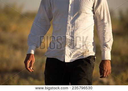 White Dirty Shirt On A Man In The Nature .
