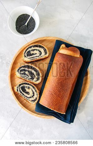 Traditional Polish Festive Pastry - Makowiec- Poppy Seed Roll Served On A Wooden Plate. White Stone 