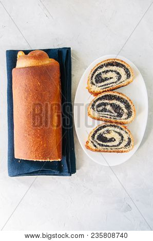 Traditional Polish Festive Pastry - Makowiec- Poppy Seed Roll Served On A Wooden Plate. White Stone 