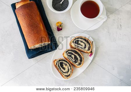 Traditional Polish Festive Pastry - Makowiec- Poppy Seed Roll Served On A Wooden Plate. White Stone 