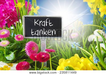 Sign With German Text Kraft Tanken Means Relax. Sunny Spring Flower Meadow With Daisy, Narcissus, Pr