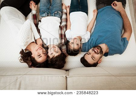 Happy Family Enjoys Comfort Of Lying On A Mattress Inside A Furniture Store. Big Family Together Che