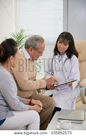 Asian Doctor Explaining Prescritption To Senior Cuople