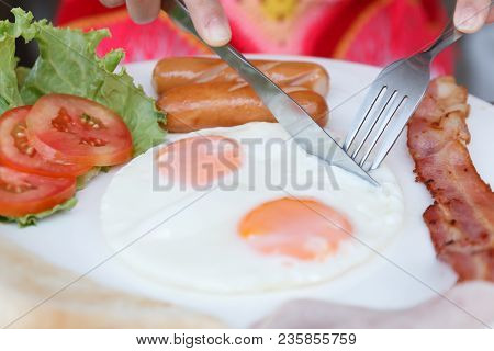 Close Up Eating Breakfast Set With Bacon Fried Egg And Ham On Wooden Table Background