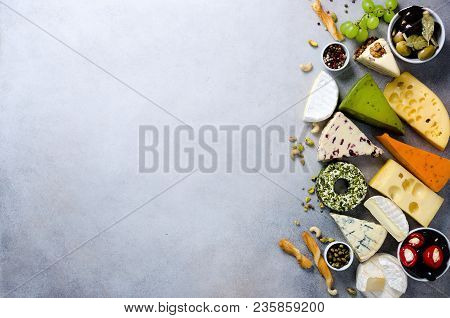Assortment Of Hard, Semi-soft And Soft Cheeses With Olives, Grissini Bread Sticks, Capers, Grape, On